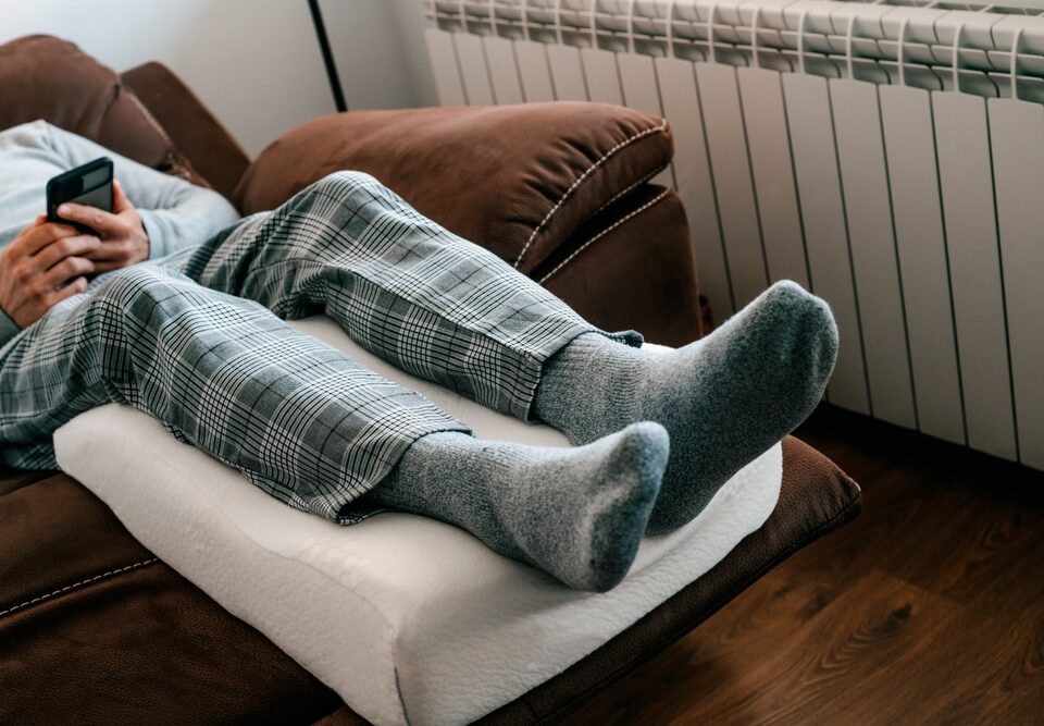 man elevating legs for good vein health